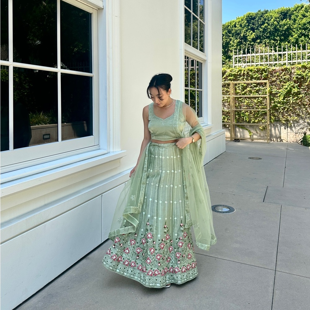 Green lehenga set with pink floral details worn for Indian wedding
